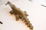 Angled top view of vintage crocodile sculpture showing its full-length textured body and tail.
