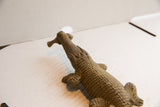 High-angle view of the vintage crocodile sculpture's intricately carved head and eyes.