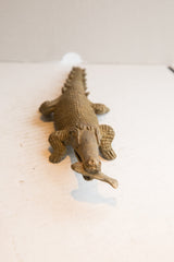 High-angle view of the entire carved crocodile sculpture eating a fish.
