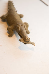 Vintage African crocodile sculpture's head showing the aged texture and fish detail.