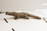 Side profile of the vintage African crocodile sculpture, showing its textured, hand-carved body.