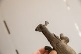 Angled view of the vintage crocodile sculpture's head showing its carved, textured details.