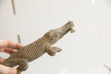 Side profile of the vintage crocodile sculpture's head showing its textured, carved details.