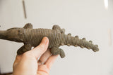 Vintage African crocodile sculpture held in a hand to demonstrate its size.