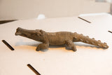Side profile of a vintage African crocodile sculpture highlighting its hand-carved, textured body.
