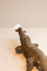 View from behind the crocodile sculpture's head, highlighting its long, textured body.