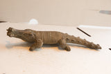 Side profile of a vintage African crocodile sculpture, showing its long body and carved texture.