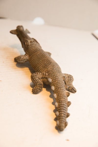 High-angle view of the carved crocodile showing its scaled back and spiny tail.