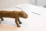 Angled view of the vintage cheetah sculpture's head and textured, patterned body.