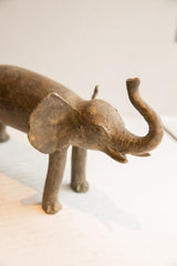 Close view of the vintage elephant sculpture's expressive face and raised trunk.