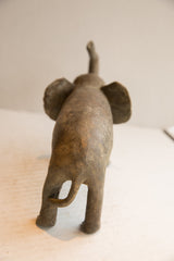 The textured back and curled tail of a vintage African elephant sculpture.