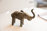 Angled view of a vintage elephant sculpture highlighting its handmade charm and textured patina.