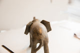 Rear view of the vintage African elephant sculpture highlighting its aged, textured surface.