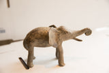 Vintage African elephant sculpture with a dark, textured patina, shown in profile view.