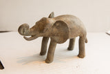 Vintage African elephant sculpture with a rustic, textured patina and upward-curled trunk.