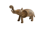 Vintage African elephant sculpture with a textured, rustic brown finish and its trunk raised.