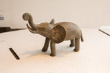Profile view of a vintage African elephant sculpture detailing its handmade, aged texture.