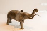 Side profile of the vintage elephant sculpture, featuring an aged patina and upturned trunk.