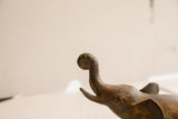 Close profile of the vintage elephant sculpture's textured, raised trunk.