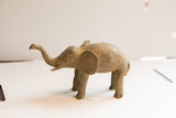 Handmade African elephant sculpture showing its aged patina and textured form in profile.