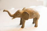 Vintage African elephant sculpture in profile, revealing a textured, handmade finish.