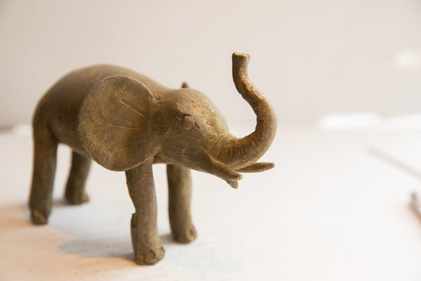 Three-quarter view of the vintage elephant sculpture highlighting its rustic, aged texture.