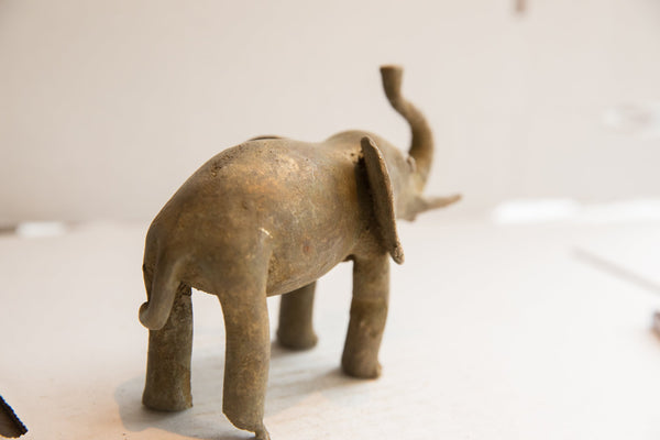 Rear three-quarter view of the vintage elephant sculpture showing its textured, aged patina.