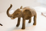 Vintage African elephant sculpture with a charming rustic texture and raised trunk.
