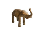 Vintage African elephant sculpture with a rustic, handmade texture and its trunk raised.