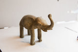 Vintage African elephant sculpture from a side angle, showing its rustic, handmade texture.