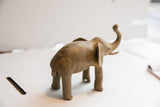 Angled view of the vintage elephant sculpture showing its textured back and form.