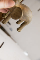 Underside view of the vintage elephant sculpture showing its textured legs and feet.
