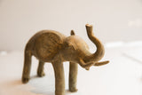 Angled view of the vintage elephant sculpture, highlighting its expressive pose and aged patina.