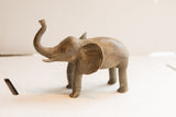 Side profile of the vintage elephant sculpture showing its raised trunk and aged texture.