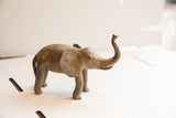 Vintage handmade elephant sculpture in profile, highlighting its time-worn textured surface.