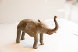 Side profile of the vintage African elephant sculpture highlighting its aged, textured surface.