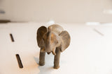 Frontal view of a vintage handmade African elephant sculpture with a matte, textured finish.