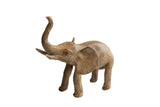 Vintage African elephant sculpture with a textured, aged finish and a raised trunk.