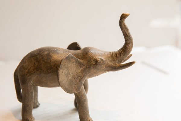 Profile view of the vintage elephant's head with its textured, raised trunk.