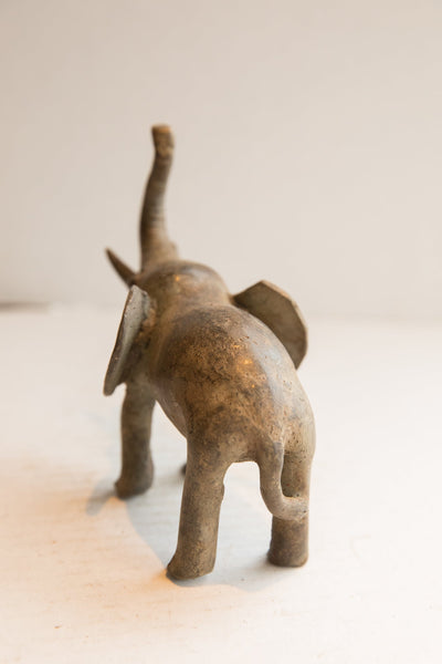 Rear view of a handmade African elephant sculpture with a weathered, textured finish.