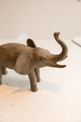 Right profile of a vintage elephant sculpture highlighting its textured, aged patina.