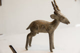 Three-quarter view of the vintage antelope sculpture showing its textured, aged patina.