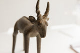 Detailed view of the vintage antelope sculpture's face, showing its textured patina and spiraled horns.