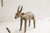 Handmade African antelope sculpture with a rustic, aged patina and detailed twisted horns.