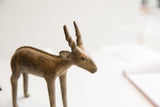 Profile detail of a handmade African antelope showing textured ears and spiraled horns.