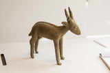 Profile view of a vintage African antelope sculpture showing its textured, braided spine detail.