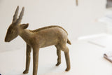 Side view of the handmade antelope sculpture showing its aged surface and braided spine.