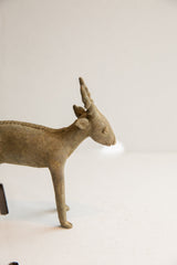 Profile view of the vintage antelope sculpture's head and horns, showing its aged, handmade texture.