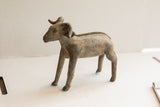 Side profile of the vintage African ram sculpture, showing its aged patina and handmade form.