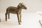 The distinct profile and weathered patina of a vintage African ram sculpture.